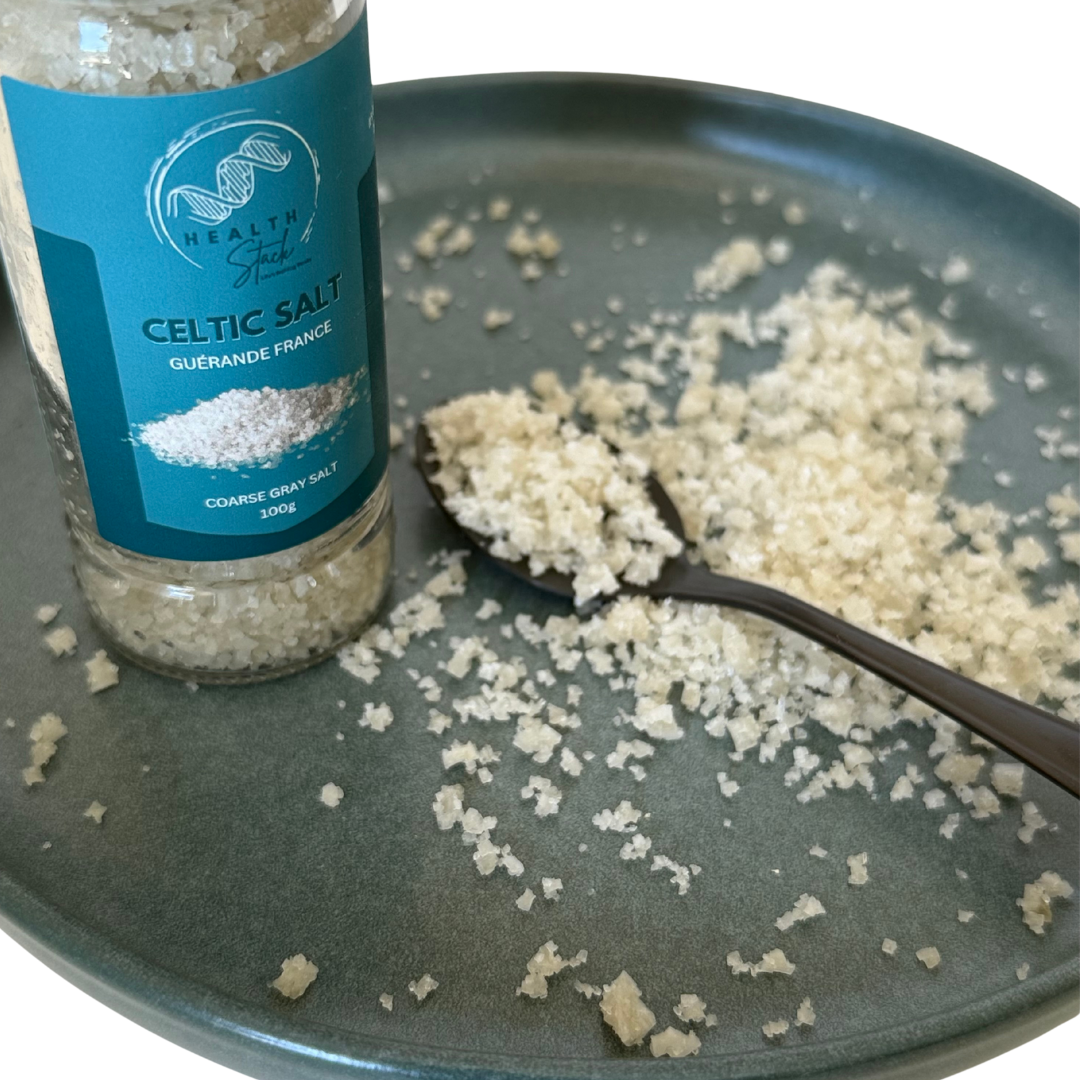 Healthstack Celtic salt container with a spoonful of salt on a dark plate