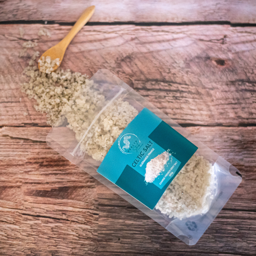 HealthStack Pouch of celtic salt with a wooden spoon on a wooden surface
