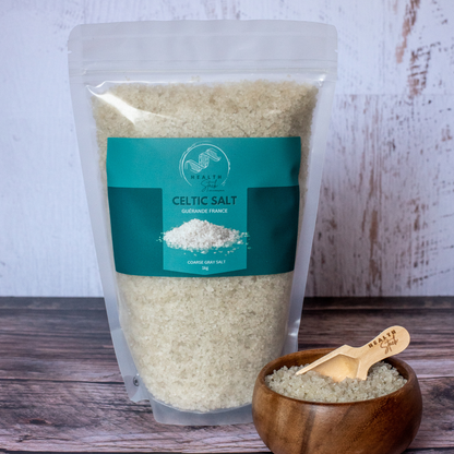 Bag of Celtic salt with a wooden bowl and spoon on a wooden surface