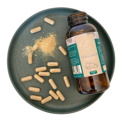Bottle of Lion's Mane supplement with capsules and powder on a dark plate